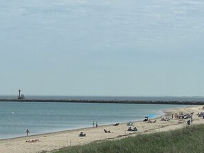 A beach with people, a lifeguard tower, and a calm sea. - The perfect family- and pet-friendly getaway steps from the sandy beach (Sandwich)