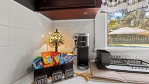 Eine Küche mit Kaffeemaschine, einer Lampe und Snacks.