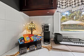 Una cocina con cafetera, lámpara y bolsas de aperitivos.