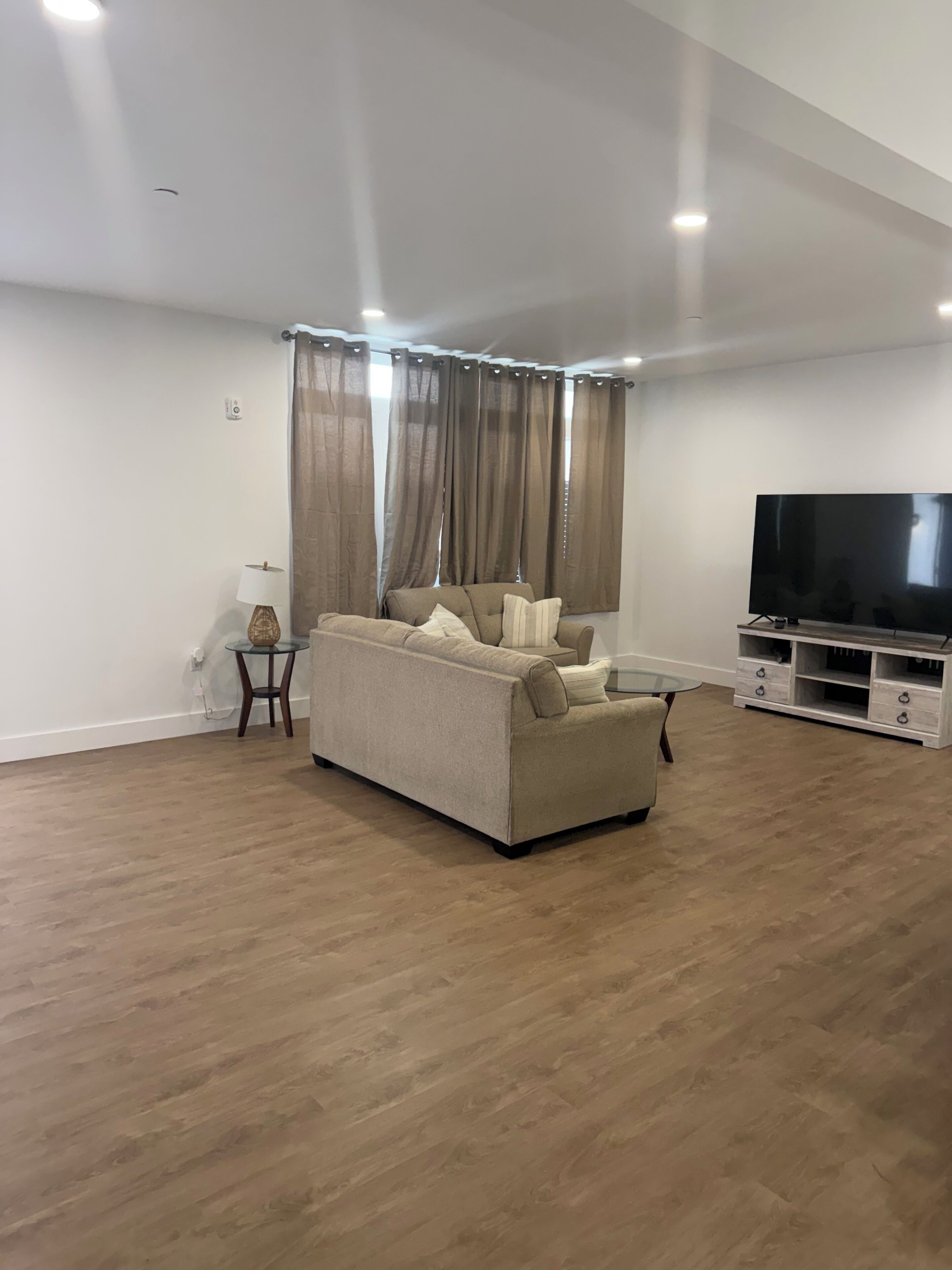 Una sala de estar con un sofá, un televisor y una mesita.