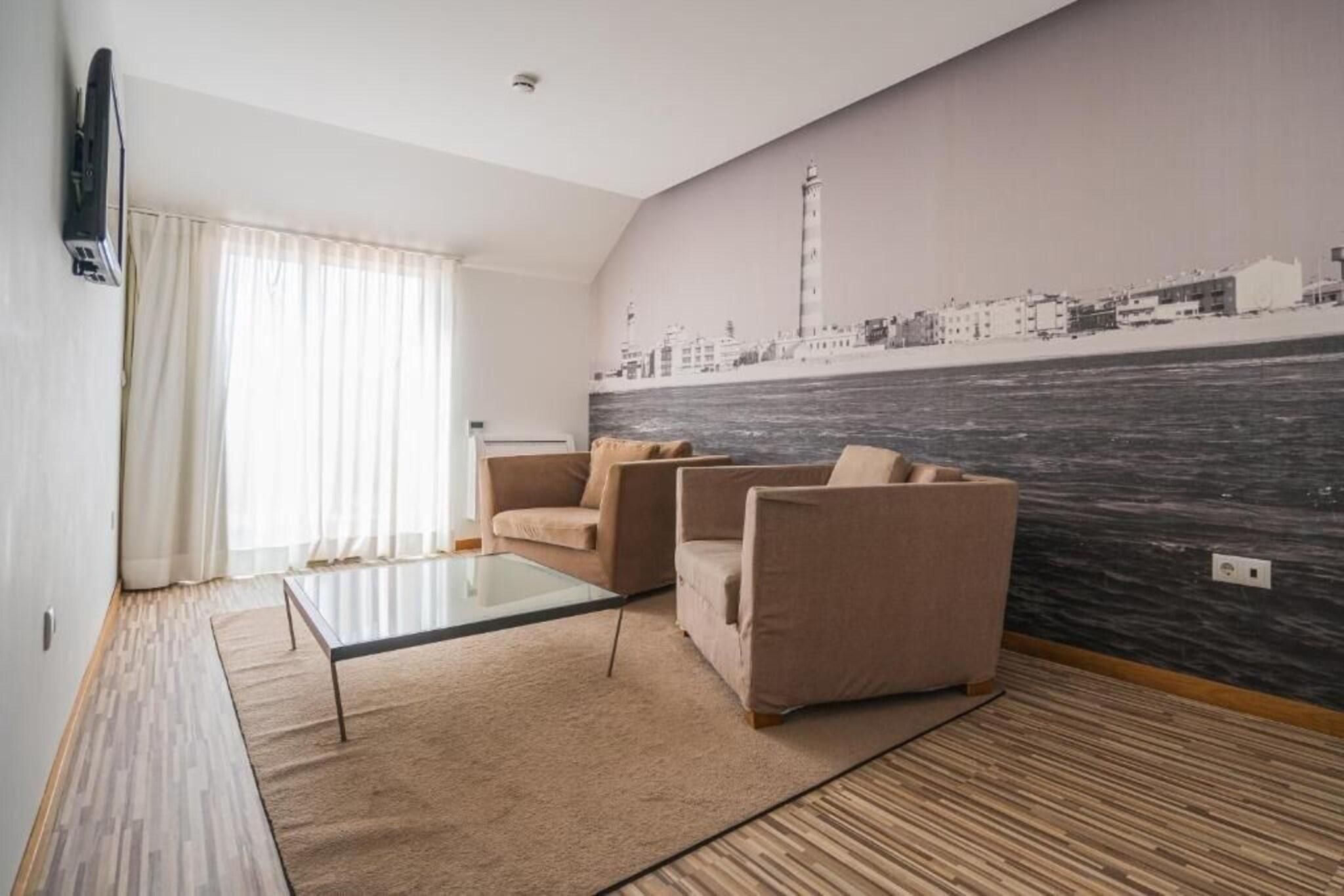 Een woonkamer met een stadsgezicht muurschildering, een flatscreen televisie en een glazen salontafel.