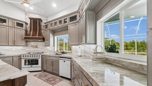 A modern kitchen with a large island, built-in oven, and a dishwasher.