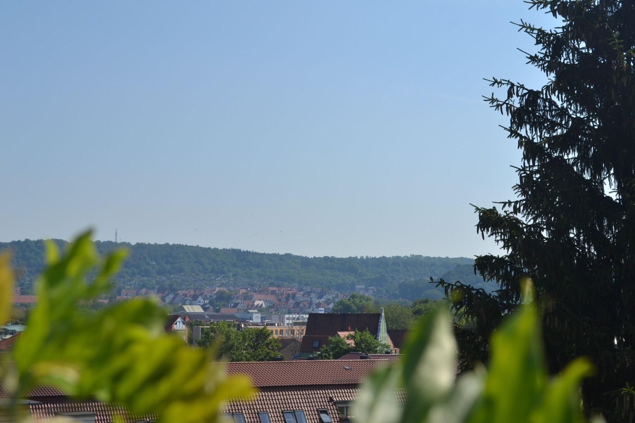 Eine Stadt mit Gebäuden und einer Hügelkulisse im Hintergrund.