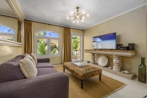 Ein Wohnzimmer mit einer Couch, einem Couchtisch, einem Fernseher und einem Kamin.