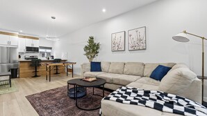 Una sala de estar moderna con sofá, mesa de centro y un tablero de ajedrez.