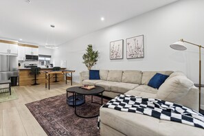 A modern living room with a sofa, coffee table, and a chessboard. - The Executive Escape|Spacious 3BR Near Downtown|Free parking|Free WiFi|Pooltable (Edmonton)