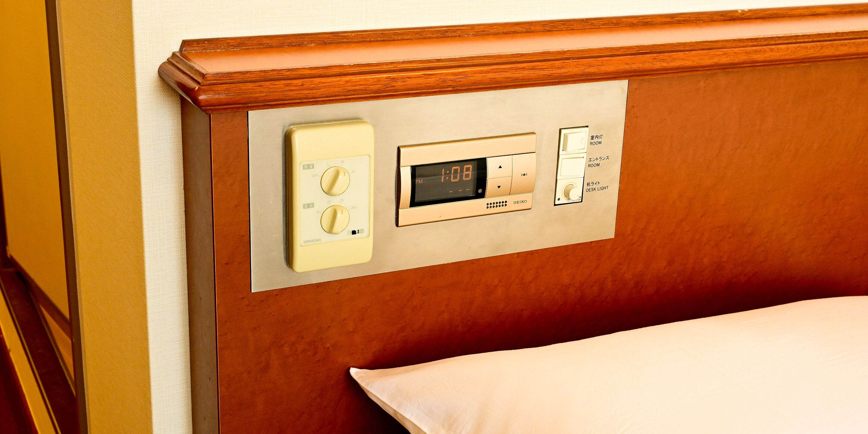 Un panneau de commande doté d’une horloge numérique, d’un thermostat et d’un interrupteur pour la lumière.