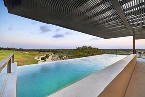 Ein Schwimmbad mit Blick auf einen Golfplatz und die Ferne.