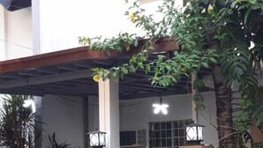 A building with a gated entrance, a covered porch, and a sign indicating a post office.