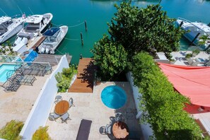 Ein Poolbereich auf dem Dach mit Blick auf den Hafen, Liegestühle und ein kleiner Tisch.