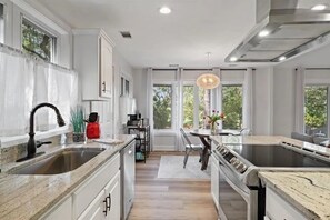 A modern kitchen with a large island, stainless steel appliances, and a view of the outdoors. - Fabulous 3-Bdrm Beach Home, Short Walk from Beach with Beautiful Golf Views (Hilton Head Island)