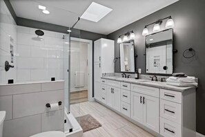 A modern bathroom with a walk-in shower, a large mirror, and a vanity with a sink and countertop. - Fabulous 3-Bdrm Beach Home, Short Walk from Beach with Beautiful Golf Views (Hilton Head Island)
