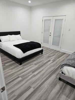 Ein Schlafzimmer mit einem Bett, einem Kleiderschrank und einer Tür.