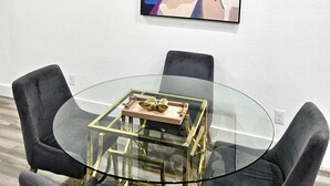 A modern dining area with a glass table, black chairs, and a framed artwork on the wall. - Comfy Modern Getaway10mins from downtown (Houston)
