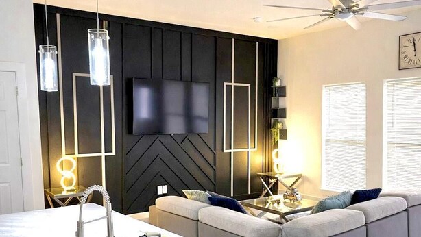 A modern kitchen with a white countertop, black trash bin, and a ceiling fan. - Comfy Modern Getaway10mins from downtown (Houston)