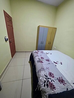 A bedroom with a bed, a wardrobe, and a door.