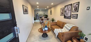 A living room with a sofa, coffee table, and framed pictures on the wall.