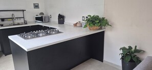 A modern kitchen with a central island, a microwave, and a gas stove.