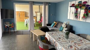 Een moderne woonkamer met een bank, een eettafel en een televisie.