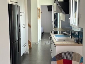Una cocina moderna con refrigerador, horno y microondas.