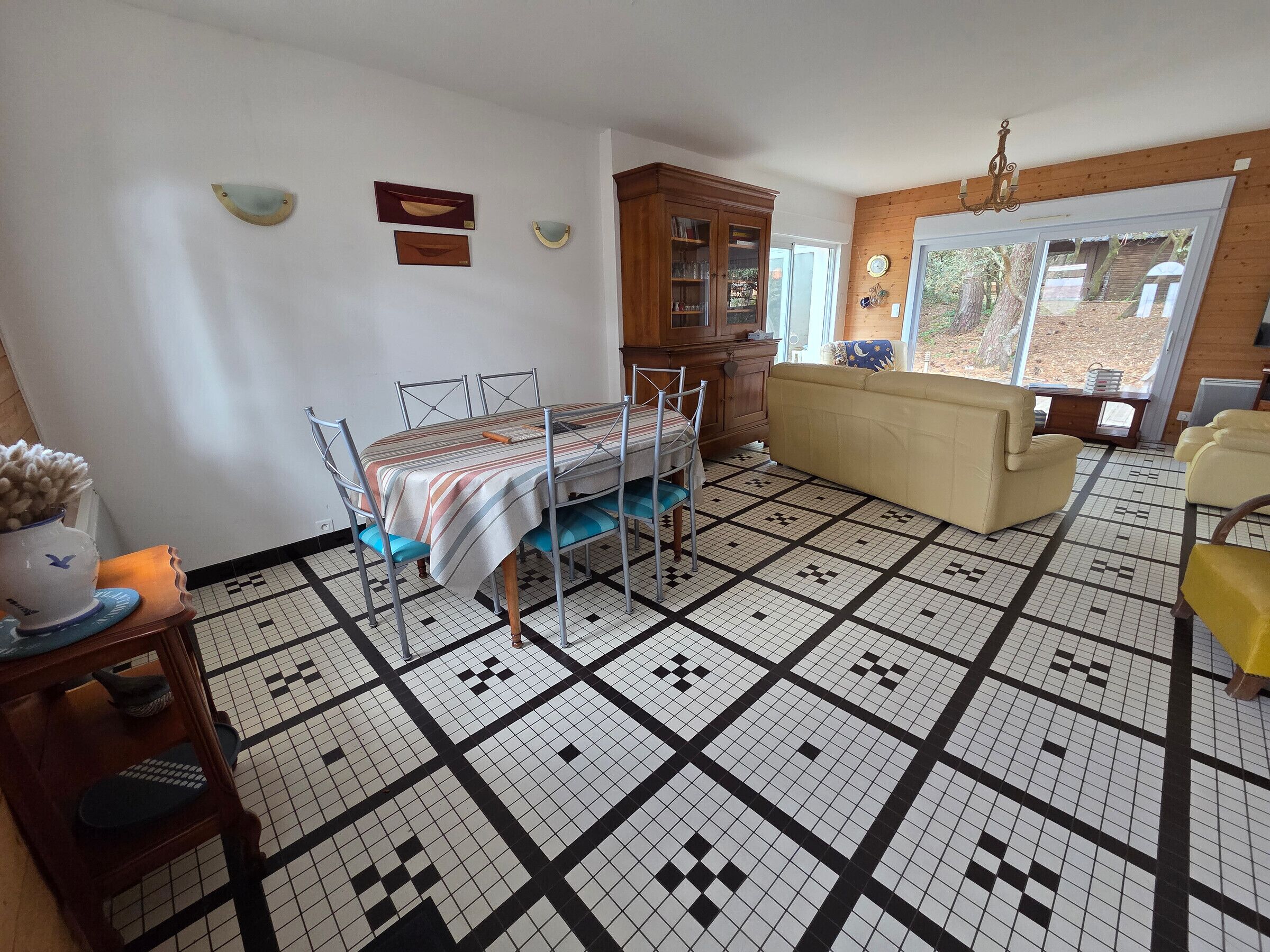Un espace repas comprenant une table, des chaises, un canapé et un meuble.