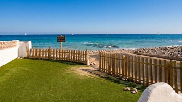 A coastal view with a wooden fence, a grassy area, and a clear blue sky. - Beachfront house with stunning views - 4 guests (Denia)