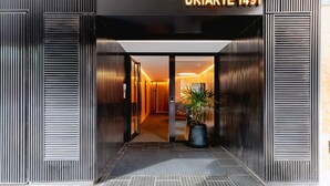 Een moderne hotelentree met een bord waarop 'URIARTE 1491' staat.