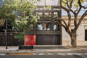 A modern building with a red door, a tree in front, and a clear sky. - MOT Rentals + Black Ravignani 2A - 3 pax Loft Palermo Hollywood (Buenos Aires)