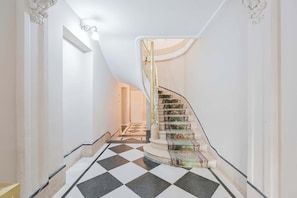 A staircase with patterned carpet runners, a checkered floor, and a white interior. - Leonardo Da Vinci Aparts 1D by MOT Rentals (Buenos Aires)