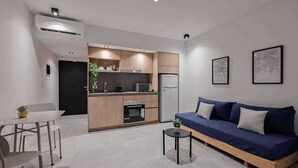 A modern kitchen with built-in appliances, a dining area with a table and chairs, and a sofa with a small side table. - MOT Rentals Black Ravignani - 3 Lux Aparts 12 pax in Palermo Hollywood (Buenos Aires)