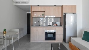 Eine moderne Küche mit Einbauofen, Kühlschrank und einem Essbereich mit Tisch und Stühlen.