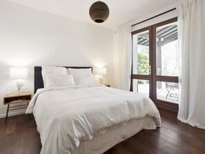 A bedroom with a bed, bedside lamps, a nightstand, and a window with curtains. - Villa lake view with pool - 12 guests (Biscarrosse)