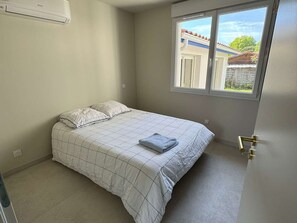 Une chambre à coucher avec un lit, une fenêtre et une porte.