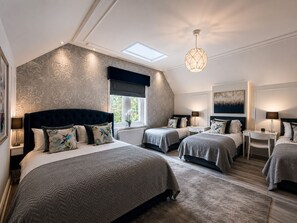 Un dormitorio con dos camas, un tragaluz, una lámpara moderna y vistas al exterior.
