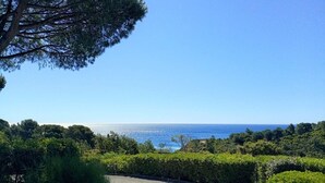 A coastal road with a clear view of the sea and lush greenery. - Studio cabin sea view - 3 guests (Cavalaire-sur-Mer)