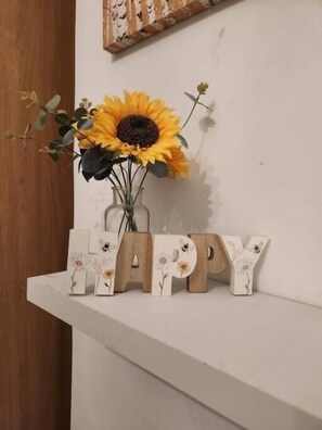 A white shelf with a sunflower vase and wooden letter blocks spelling 'HAPPY'. - Apartment Sleeps 4  2nd floor apartment (Brighton)