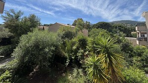 A residential area with houses, dense greenery, and a clear sky. - Apartment with AC, terrace - 4 guests (Cavalaire-sur-Mer)