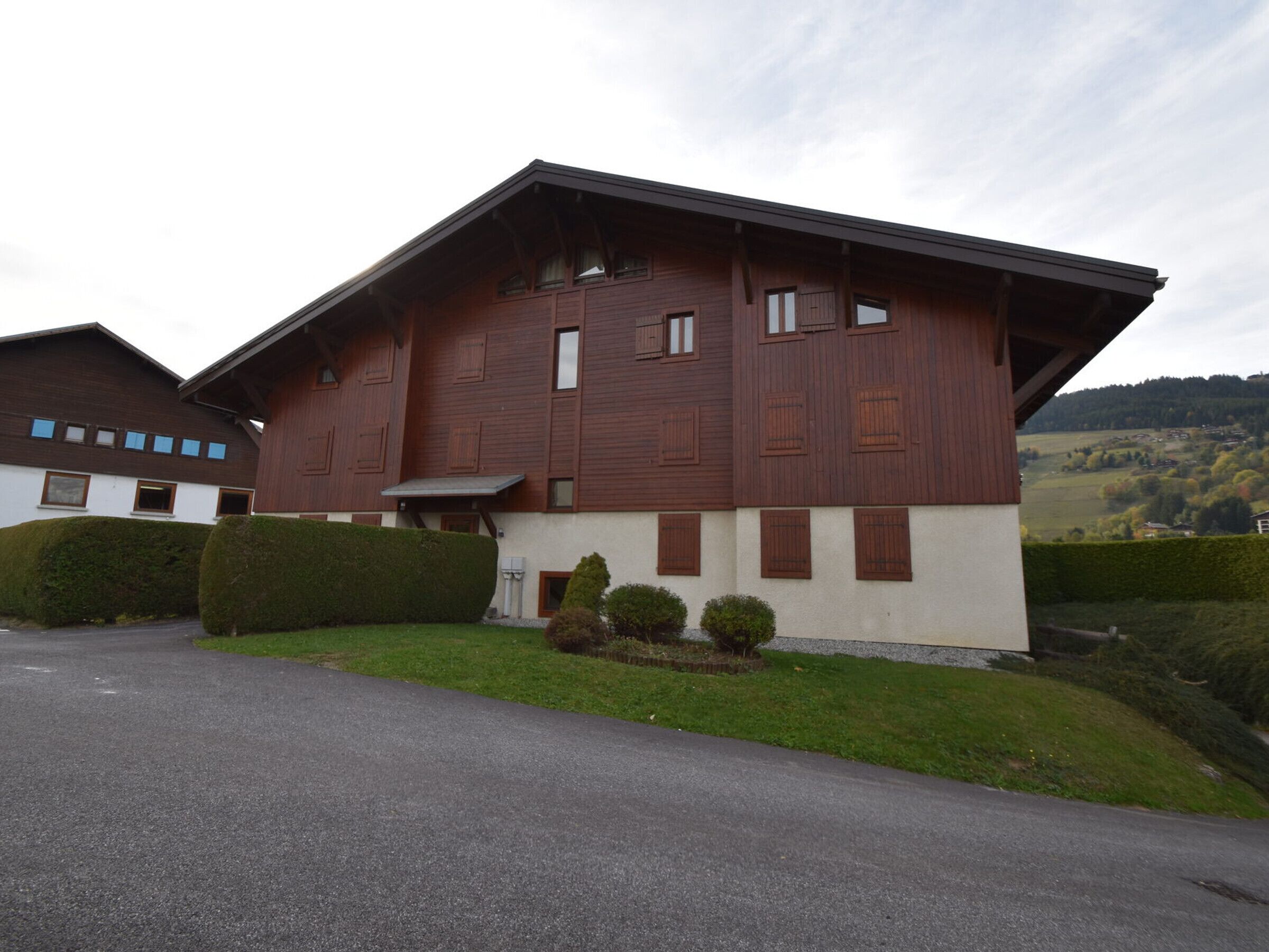 Une maison moderne à deux étages, dotée d’un toit en pente, de grandes fenêtres et d’une pelouse bien entretenue.