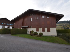 Ein modernes, zweistöckiges Haus mit Satteldach, großen Fenstern und einem gepflegten Rasen.