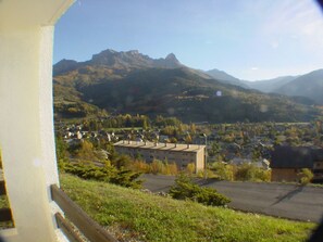 Ein Wohngebiet mit Häusern, einem großen Gebäude und Bergen im Hintergrund.