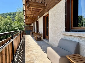 Ein Balkon mit Holzgeländern, einer Couch und einem Tisch.