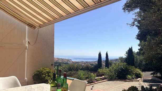 Eine Terrasse mit Tisch, Stühlen und alkoholischen Getränken.