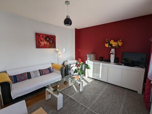 Una sala de estar moderna con sofá, mesa de centro y una pared de acento roja.