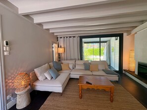 Ein modernes Wohnzimmer mit einem Ecksofa, einem Holztisch und einem Kamin.