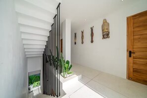 Un interno moderno con una scala, una porta in legno e decorazioni a parete.