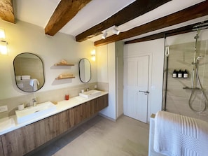 A bathroom with two sinks, a mirror, a shower, and wooden beams on the ceiling. - Charming cottage in Candes-St-Martin - 8 guests (Candes-Saint-Martin)