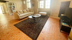 A living room with a sofa, a coffee table, a rug, a fireplace, and a television.
