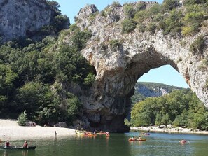 A natural rock arch formation with kayaks on a calm body of water. - Mobile home with AC, pets allowed - 5 guests (Vesseaux)