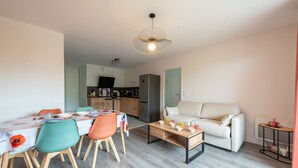 Ein modernes Wohnzimmer mit Essbereich, einer Couch und einem Couchtisch.