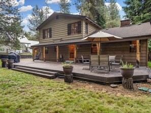 A two-story log cabin with a covered patio, outdoor seating, and a large window. - Sauna Hot Tub Game Room McCall (McCall)
